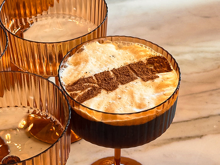 Espresso Martini with Sup Logo in Cocoa Powder on top of foam.