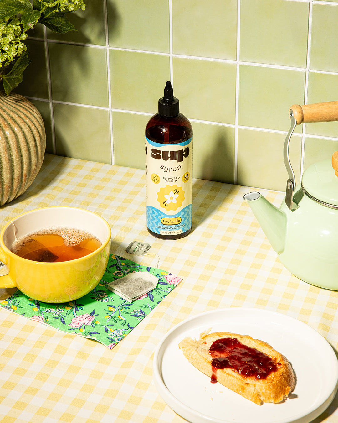 Very Vanilla Sup Syrup bottle on a kitchen counter with a cup of London fog tea and toast with jam.